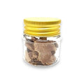 Clear glass jar with yellow lid containing slices of freeze dried white truffle Tuber magnatum Picco