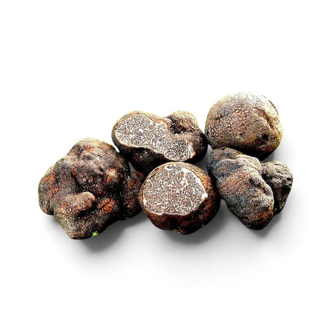 Close view of Tuber macrosporum truffles with smooth dark surfaces and marbled interiors